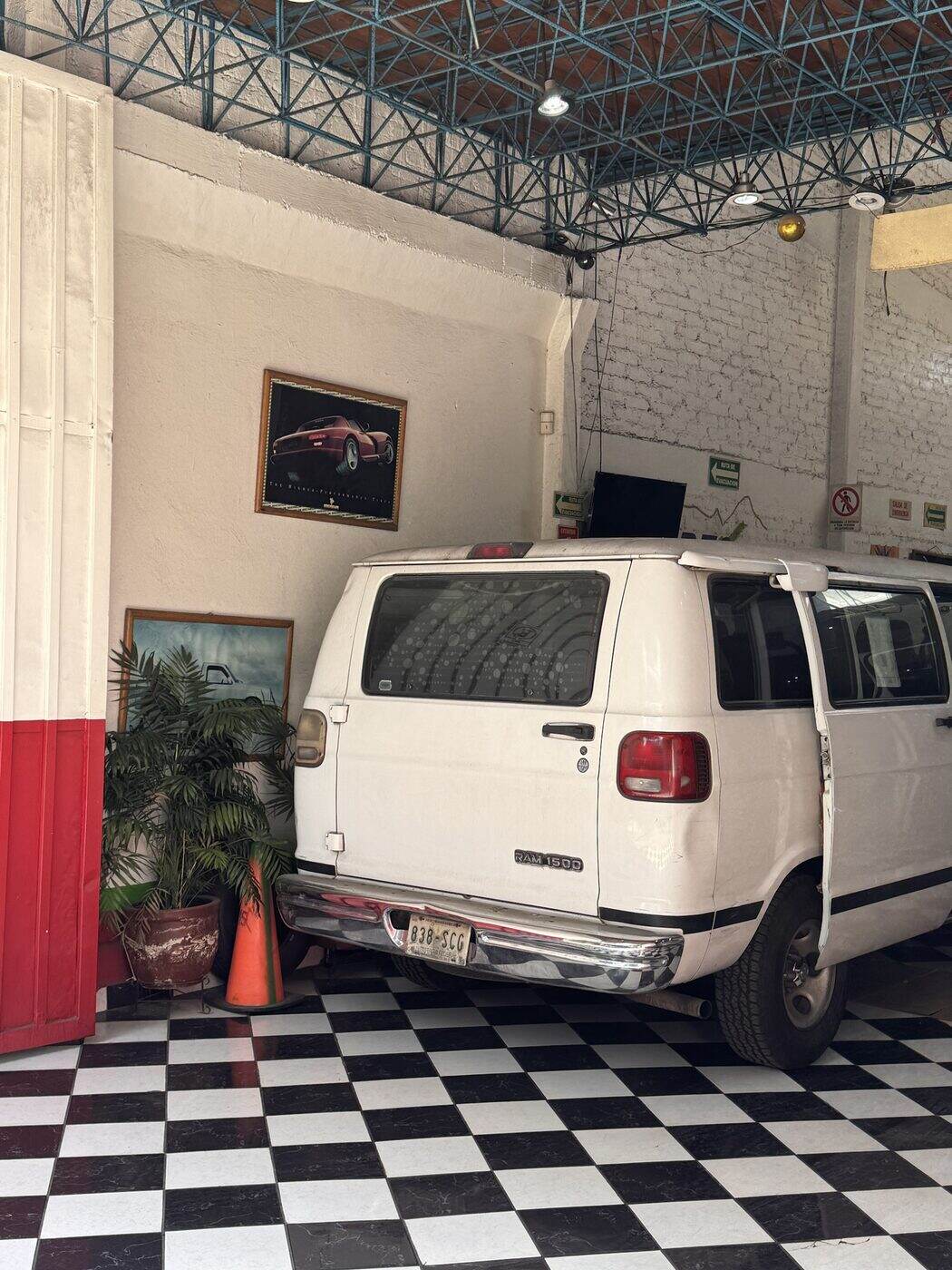 Camioneta blanca en un taller con piso ajedrezado